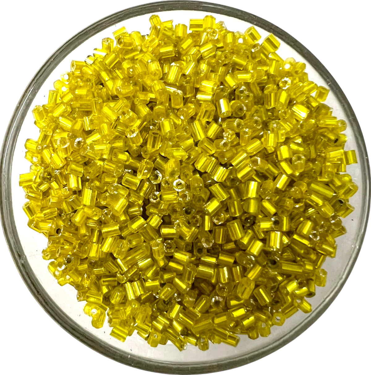 Loose yellow cut glass beads for DIY jewelry making spread out on a clean white background.